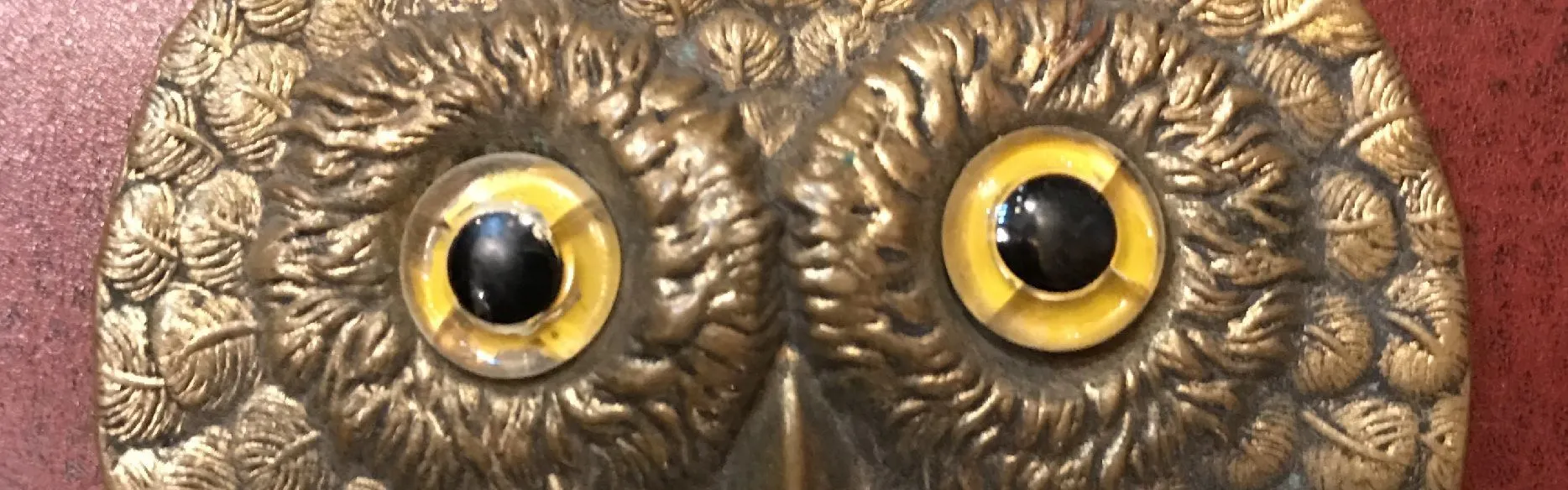 Owl head relief with yellow eyes.